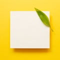 White memo pad with green leaf on yellow background Royalty Free Stock Photo