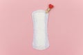 White daily, menstrual woman pad for hygiene or blood period with red pin with a heart as symbol of body love. Concept