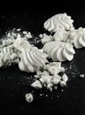 White meringues candy on black slate plate kitchen table
