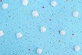 White meringues and colorful confetti on blue background.