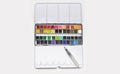 White metal box with watercolors, brush and palette on a light gray background Royalty Free Stock Photo