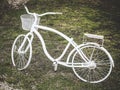 White metal decorative bike with flower pot stands on the lawn