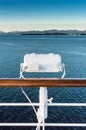 White metal exterior light fixture on railing of cruise ship, Alaska Inside Passage route. Royalty Free Stock Photo