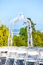 White metal folding chairs lined up for outdoor wedding with arbor and view Royalty Free Stock Photo