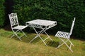 White metal garden furniture table and two chairs Royalty Free Stock Photo
