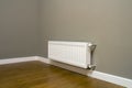 White metal heating radiator mounted on gray wall inside a room Royalty Free Stock Photo