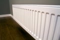 White metal heating radiator mounted on gray wall inside a room Royalty Free Stock Photo