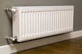 White metal heating radiator mounted on gray wall inside a room Royalty Free Stock Photo