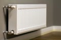 White metal heating radiator mounted on gray wall inside a room Royalty Free Stock Photo