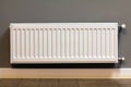 White metal heating radiator mounted on gray wall inside a room Royalty Free Stock Photo
