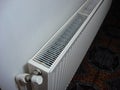 White metal heating radiator mounted on a wall in room interior.  Bucharest, Romania, 2019 Royalty Free Stock Photo