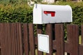 White metal mailbox mounted on a rustic fence Royalty Free Stock Photo