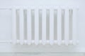 White metal retro radiator of water heating on  background of a white wall in the room Royalty Free Stock Photo