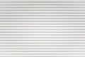 White metal roller shutter door background. Steel stripe horizontal lines of iron foldable metal sheet texture. Empty front Royalty Free Stock Photo