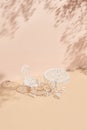 White metal table and chair on beige background. Minimal creative layout with sunshine and hard shadow. Tree shadow on pastel pink