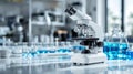 White microscope on a laboratory table with blue liquid in glass beakers Royalty Free Stock Photo