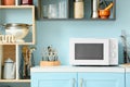 White microwave oven on blue counter in stylish kitchen Royalty Free Stock Photo