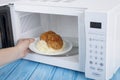 White microwave oven, on a blue wooden surface for heating food Royalty Free Stock Photo