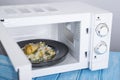 White microwave oven, on a blue wooden surface for heating food