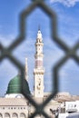 White minaret of the Prophet\'s Mosque through the bars in the city of Medina