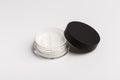 White mineral makeup in container with twist seal sifter powder isolated on white background