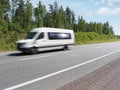 White mini bus on country highway, motion blur