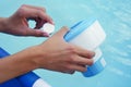 White mini chlorine tablet in the hand of a service worker for disinfection of swimming pools. The beginning of the Royalty Free Stock Photo