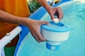 White mini chlorine tablet in the hand of a service worker for disinfection of swimming pools. The beginning of the Royalty Free Stock Photo