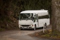 White minibus driving along a dirt road