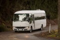 White minibus driving along a dirt road