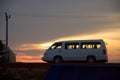 White minibus at sunset on a dirt road