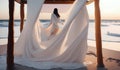 white minimalistic canopy bed with girl on the beach