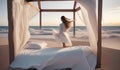 white minimalistic canopy bed with girl on the beach