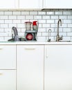 White minimalistic kitchen interior and design. Tile wall background. Household appliances - blender, vacuum machine Royalty Free Stock Photo