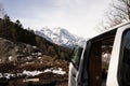 White minivan with open doors parked in a rural area with snow-capped mountains in the background Royalty Free Stock Photo