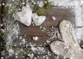 White mittens and snow hearts on a wooden plank background with copy space