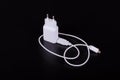 White mobile phone charger on black background Royalty Free Stock Photo