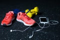 A white mobile phone with headphones, pink sneakers, two yellow dumbbells and expander on a blurred background. Royalty Free Stock Photo