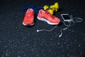 A white mobile phone with headphones, pink sneakers, two yellow dumbbells and expander on a blurred background. Royalty Free Stock Photo