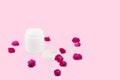 White mocap jar for cream, balm, lotion and a small pink-Red roses on a pink background. Isolated Royalty Free Stock Photo