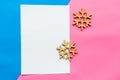 White mockup blank and Christams wooden snowflakes on geometric pink and blue background.