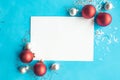 White mockup blank decorative with silver tinsel and baubles on bright blue background. Royalty Free Stock Photo