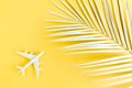 White model plane, airplane and palm leaf on yellow background. Top view, flat lay. Travel, vacation concept. Royalty Free Stock Photo