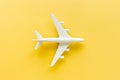 White model plane, airplane on yellow background. Top view, flat lay. Royalty Free Stock Photo