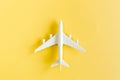 White model plane, airplane on yellow background. Top view, flat lay. Royalty Free Stock Photo