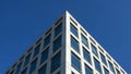 White modern building corner with blue glass windows against clear blue sky architecture Royalty Free Stock Photo