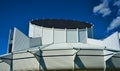 White modern building with roof round behind blue sky en clouds Royalty Free Stock Photo