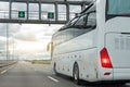 White modern comfortable tourist bus driving through highway at bright sunny day. Travel and coach tourism concept. Trip journey Royalty Free Stock Photo