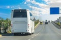White modern comfortable tourist bus driving through highway at bright sunny day. Travel and coach tourism concept. Trip journey Royalty Free Stock Photo