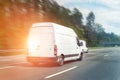 White modern delivery small shipment cargo courier van moving fast on motorway road to city urban suburb. Business distribution Royalty Free Stock Photo